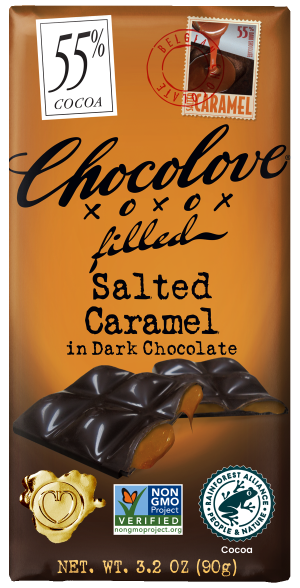 Front of a Chocolove Salted Caramel in Dark Chocolate bar wrapper. The background is a warm orange color with the product name "Salted Caramel in Dark Chocolate" displayed in bold black letters. The top right corner features a stamp with the word "Caramel" and the percentage "55% cocoa" along with a small illustration of a swirl of caramel. The bar is shown with a section broken off, revealing the salted caramel filling inside. The wrapper also includes logos for Non-GMO Project Verified and Rainforest Alliance Certified, along with a heart-shaped seal at the bottom.