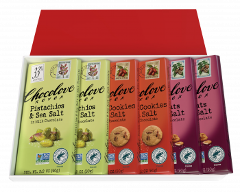 An open Chocolove 6-Bar Nut & Sea Salt Trio Pack gift box reveals six full-sized chocolate bars neatly arranged inside. The assortment includes two bars of each featured flavor: Pistachios & Sea Salt in Milk Chocolate, Cookies & Salt in Dark Chocolate, and Pecans & Salt in Dark Chocolate. The bars are wrapped in vibrant packaging—light green for Pistachios & Sea Salt, warm orange for Cookies & Salt, and rich burgundy for Pecans & Salt—each adorned with elegant Chocolove branding and an illustrated postage stamp depicting the key ingredient. The box itself has a clean white interior with a bold red lid, adding a festive and premium touch. Certification logos for Non-GMO Project Verified and Rainforest Alliance Certified Cocoa appear on each bar, highlighting the brand’s commitment to quality and sustainability.