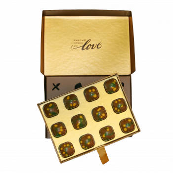 Open Chocolove Dubai Style Pistachio & Kadayif Milk Chocolate Gift Box with gold inner lid reading “Share it with someone you love” and tray of 12 decorated chocolates.